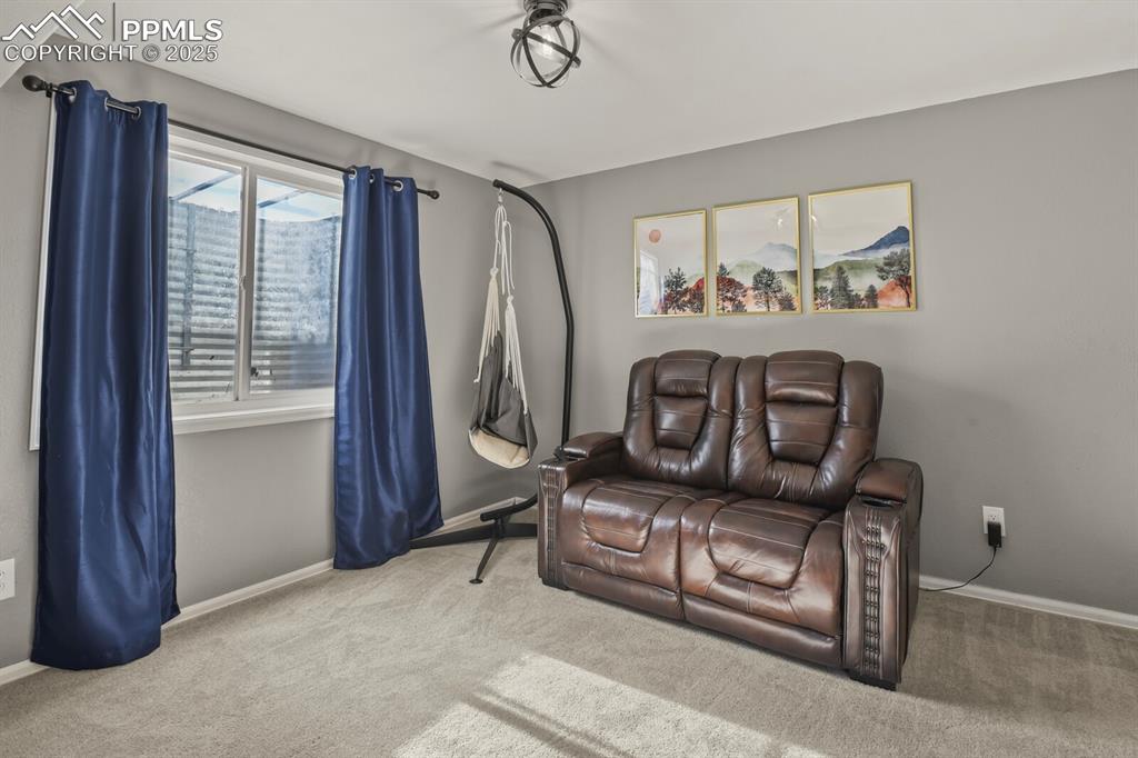 Image 28 of 50: Living area with carpet floors and baseboards