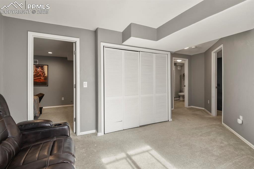 Image 29 of 50: Bedroom with light carpet, a closet, and ensuite bathroom