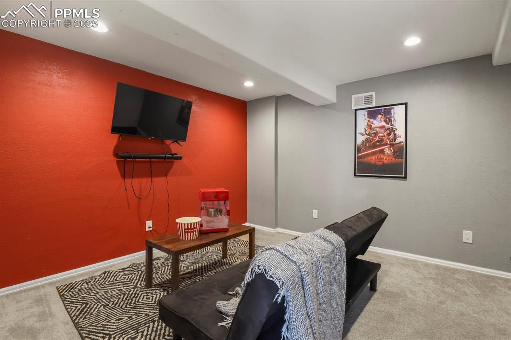Image 31 of 50: Living area with light carpet, recessed lighting, and a textured wall