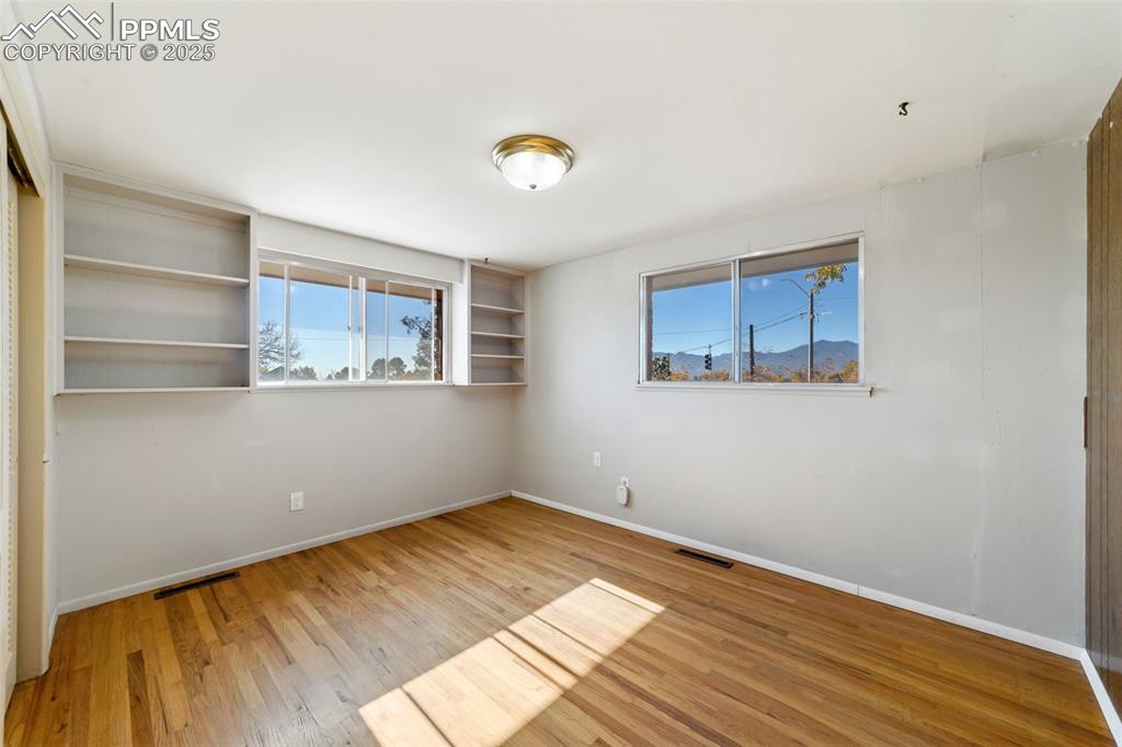 Image 19 of 49: Empty room with light wood-type flooring and a mountain view