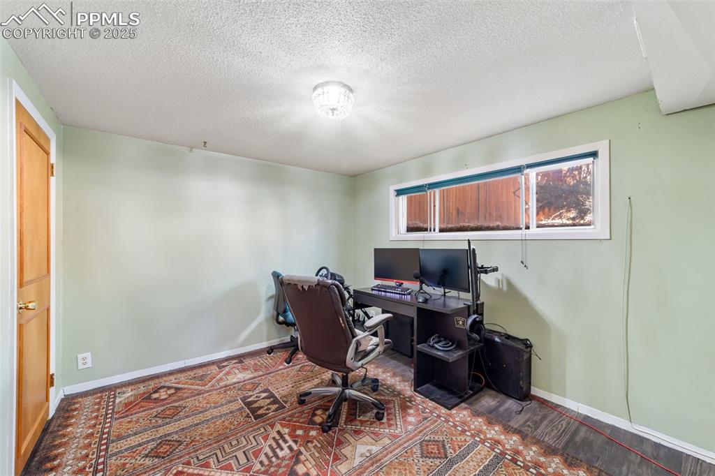 Image 31 of 49: Office space with a textured ceiling and wood finished floors