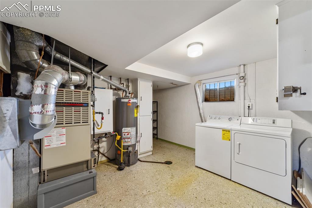 Image 35 of 49: Laundry area featuring gas water heater, washer and clothes dryer, and heat