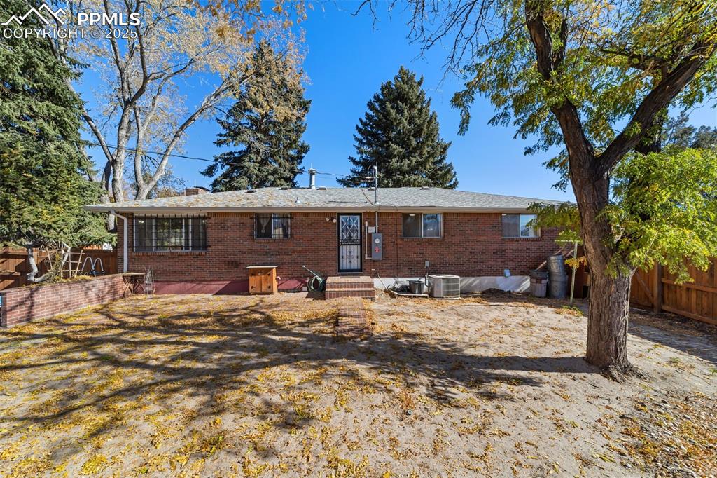 Image 39 of 49: Rear view of house with brick siding and entry steps