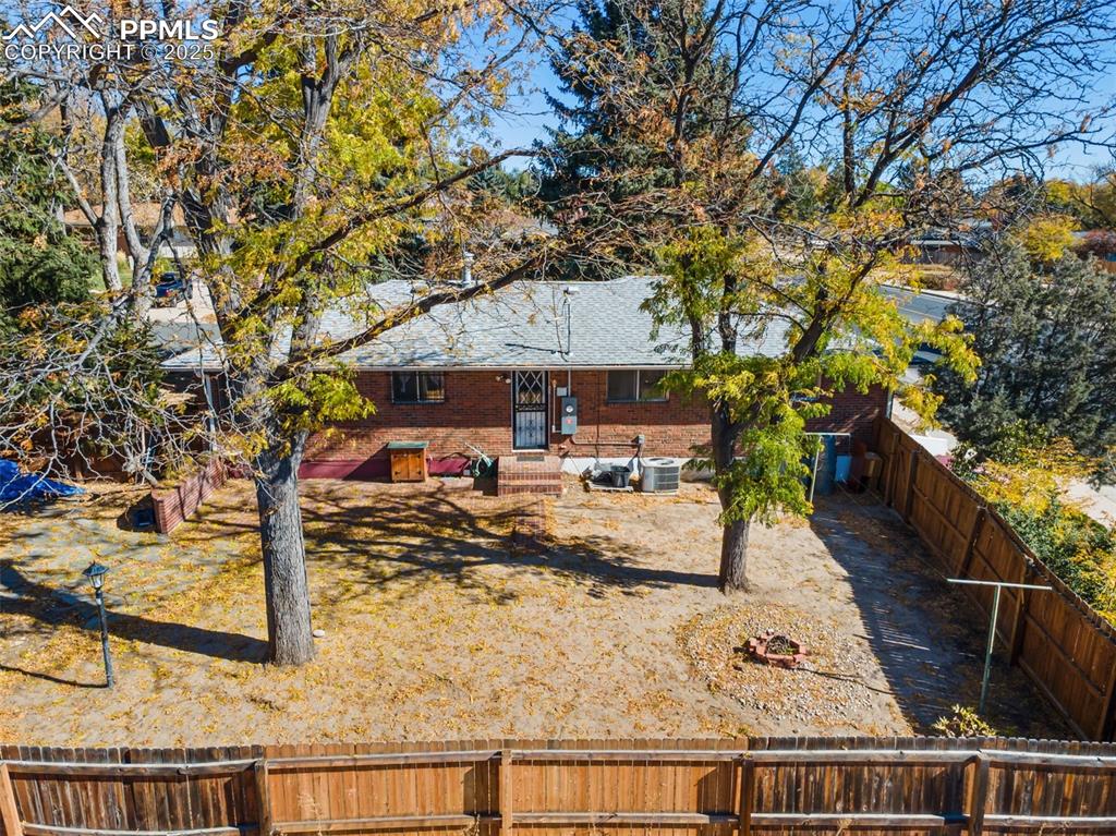 Image 45 of 49: Rear view of house featuring a fenced backyard and brick siding