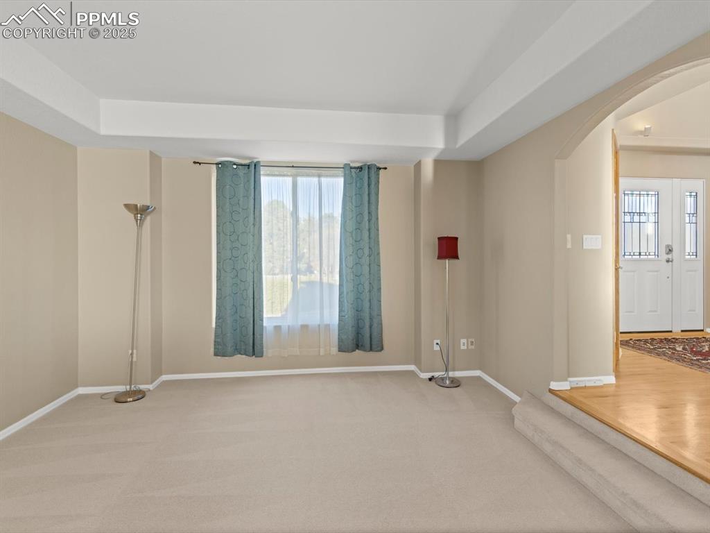 Image 10 of 49: Carpeted spare room with arched walkways and baseboards