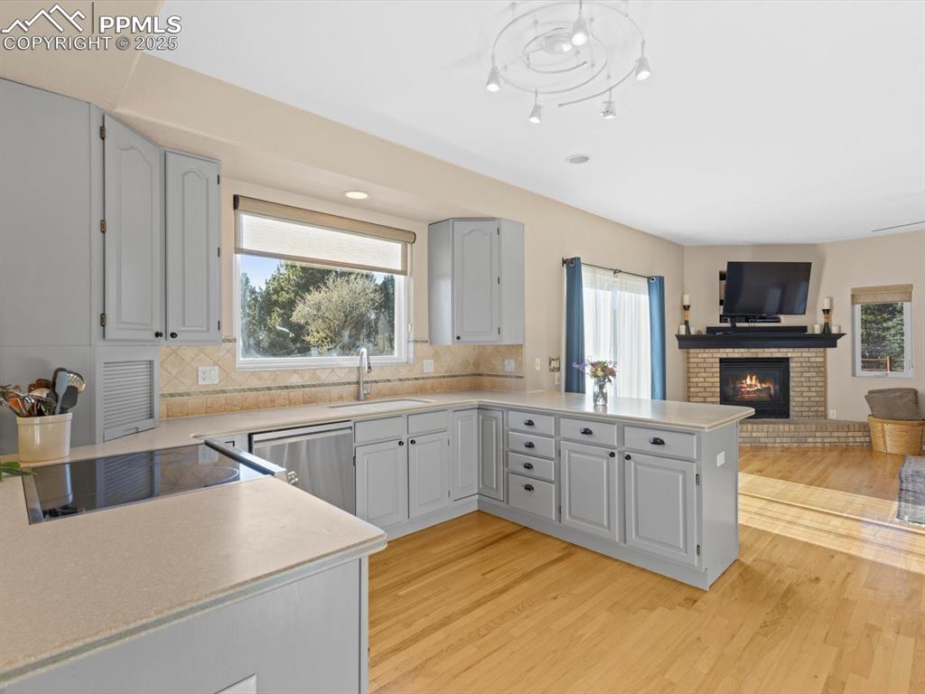 Image 17 of 49: Kitchen featuring a peninsula, open floor plan, decorative backsplash, plen