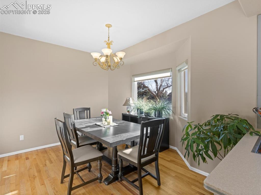 Image 20 of 49: Dining area with light wood-type flooring and a chandelier