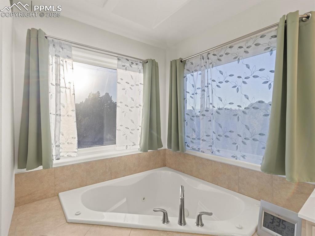 Image 25 of 49: Bathroom featuring a tub with jets