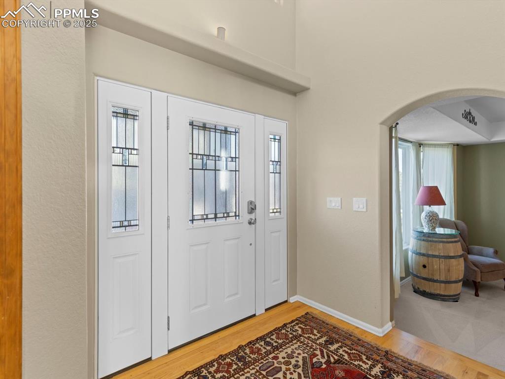 Image 4 of 49: Foyer with light wood-style floors, plenty of natural light, and arched wal