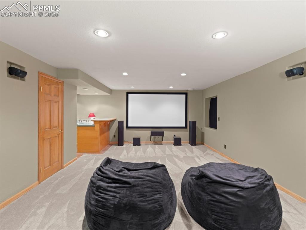 Image 41 of 49: Home theater room featuring light colored carpet and recessed lighting
