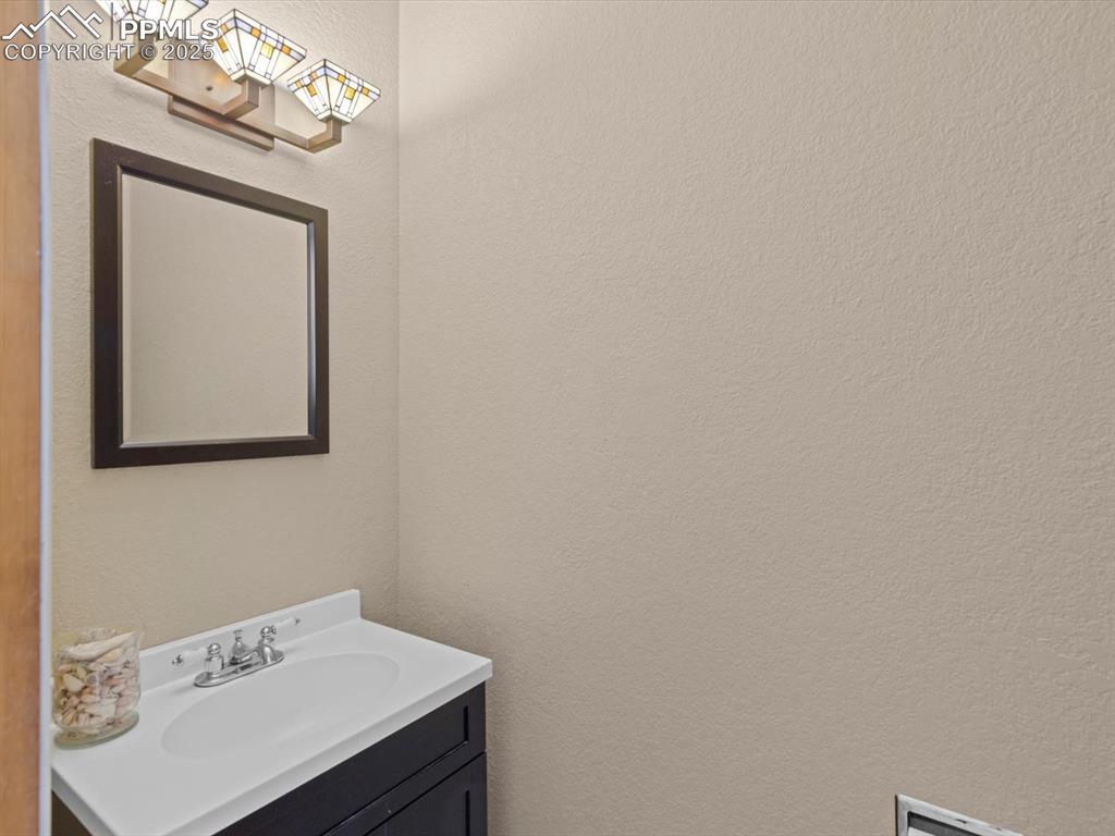 Image 44 of 49: Bathroom with a textured wall and vanity