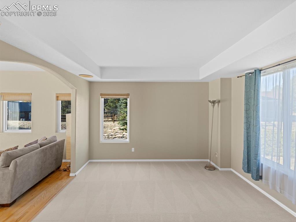 Image 9 of 49: Unfurnished living room featuring arched walkways, light colored carpet, an