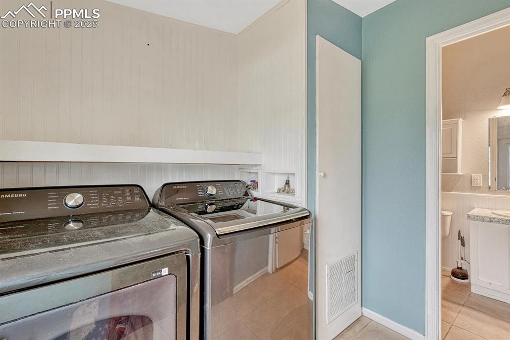 Image 27 of 38: Laundry room featuring tile patterned floors and washer and dryer that conn