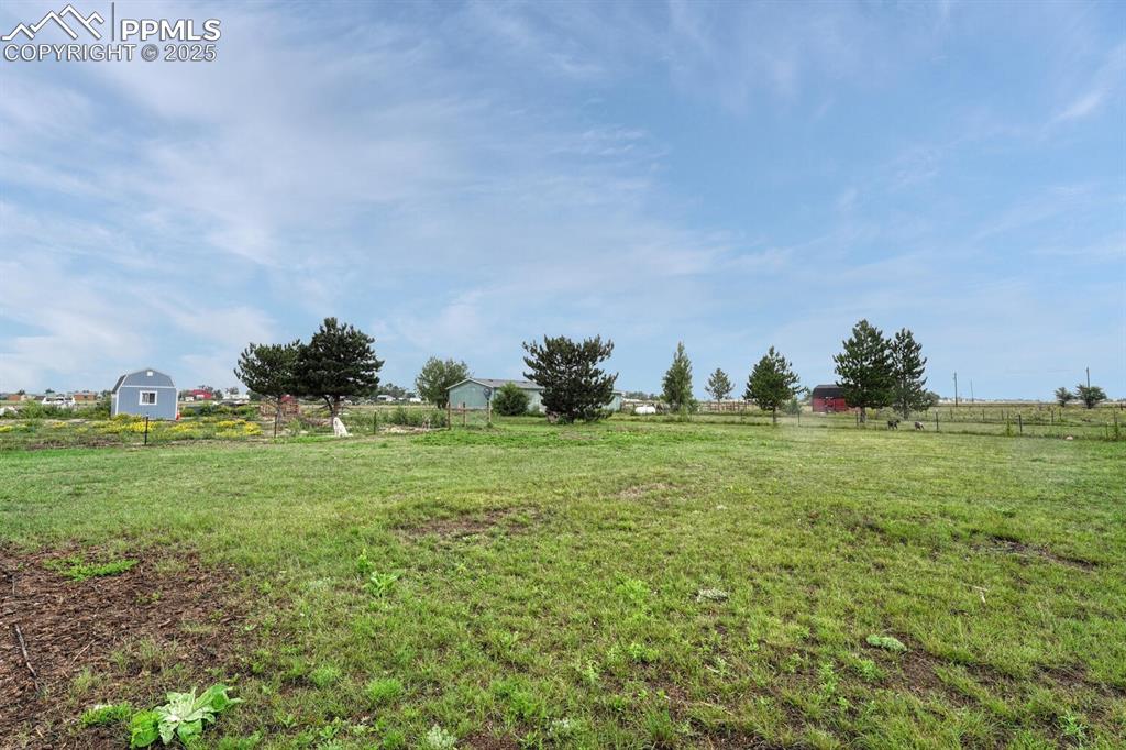 Image 31 of 38: View of yard side pasture that also includes a tuff shed.