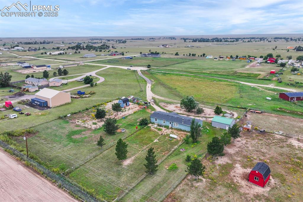 Image 34 of 38: View of property showing house, garage and both tuff sheds. 