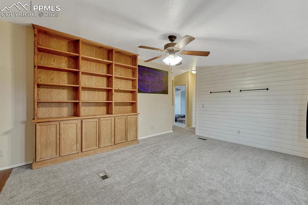 Image 7 of 38: Unfurnished living room featuring lofted ceiling, light colored carpet,ceil