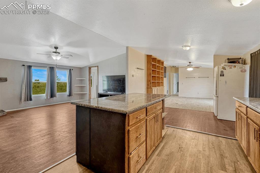 Image 9 of 38: Kitchen with open floor plan, a textured ceiling, light wood-type flooring,