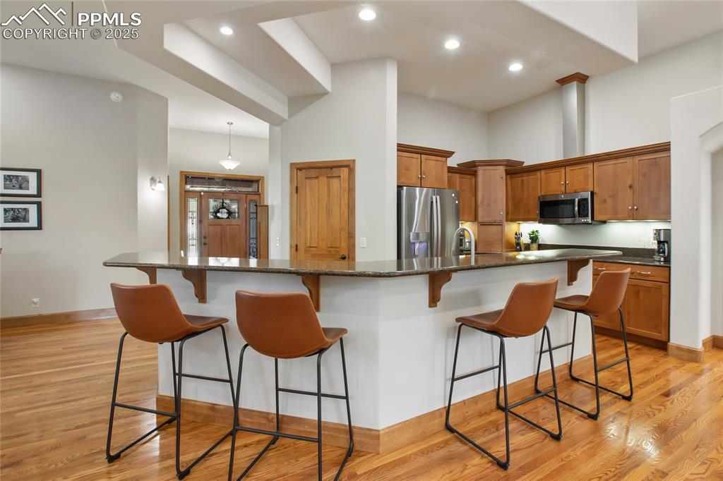 Image 18 of 49: Open concept kitchen with granite covered island on main level