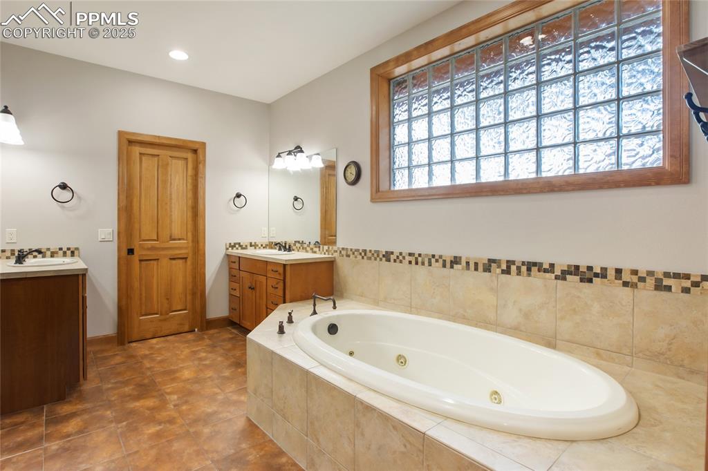 Image 22 of 49: Main level primary bathroom with Jacuzzi tub 