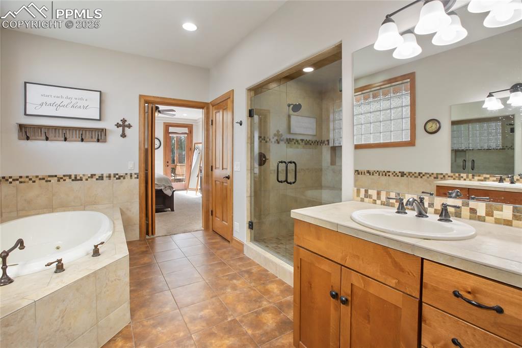 Image 23 of 49: Main level primary bathroom with Jacuzzi tub and walk in double shower 