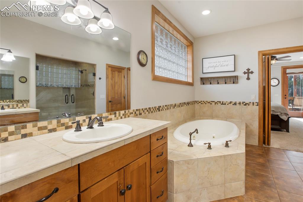 Image 24 of 49: Main level primary bathroom with Jacuzzi tub and 2 separate vanities