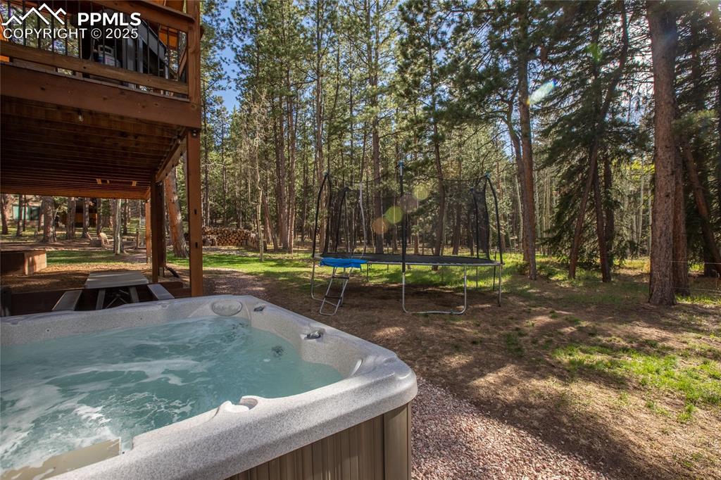 Image 8 of 49: Hot tub with view of forest