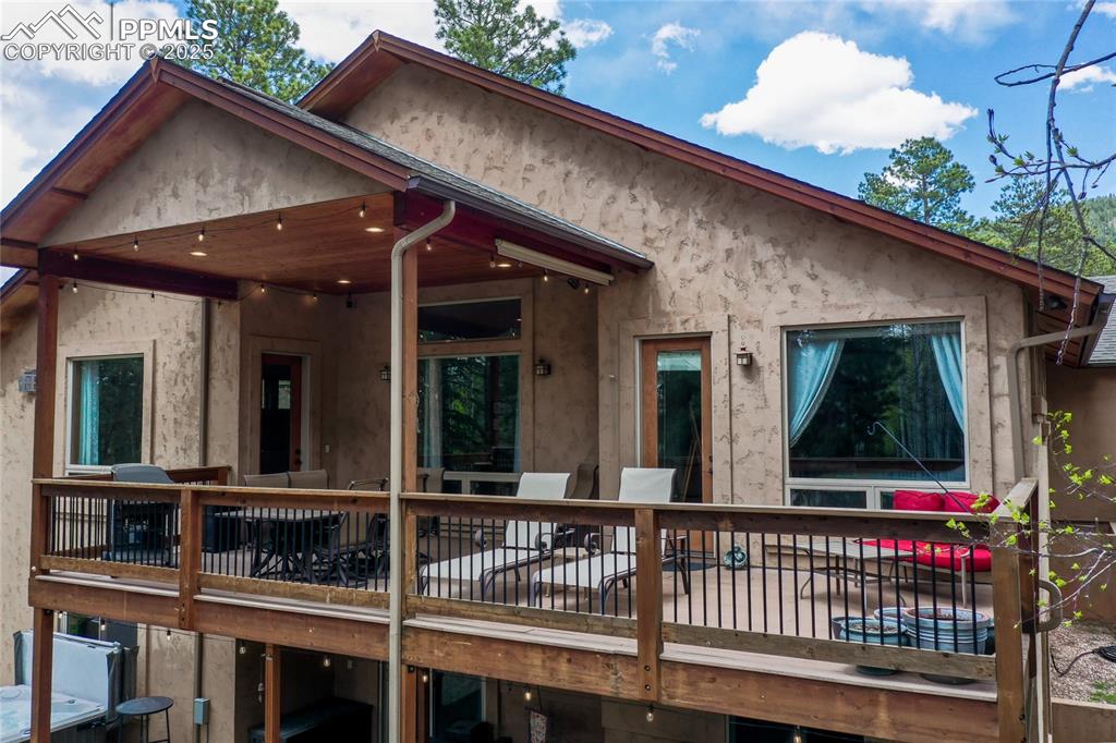 Image 9 of 49: Partially covered deck with walk out from entrances from living room and pr