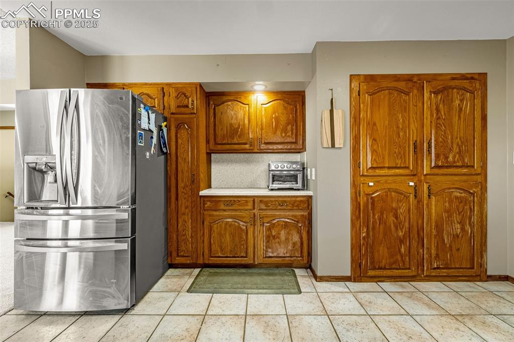 Image 12 of 42: Kitchen featuring stainless steel refrigerator with ice dispenser, light co