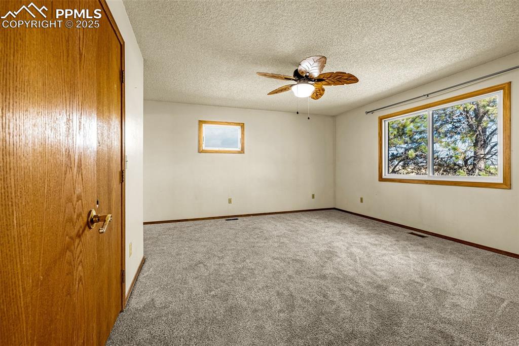 Image 18 of 42: Carpeted empty room featuring a textured ceiling and a ceiling fan