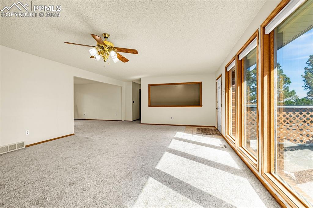 Image 7 of 42: Empty room with a textured ceiling, light colored carpet, and a ceiling fan