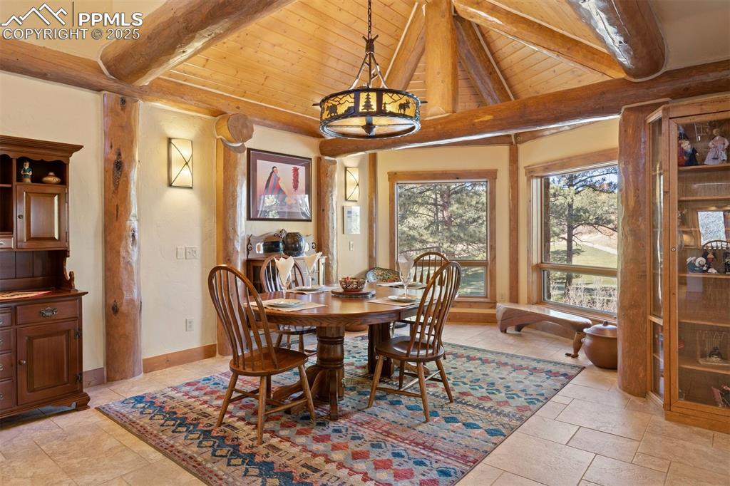Image 10 of 41: Cozy dining area with vaulted ceiling and views of the greens and trees. 