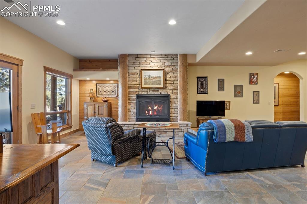 Image 19 of 41: Recreation room fireplace and sitting area with walkout to the lower patio 