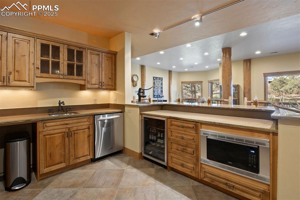 Image 21 of 41: The wet bar has everything you could need with a dishwasher, beverage fridg
