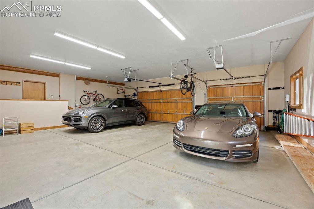 Image 27 of 41: Oversized three-car garage with extended depth and length, workbench and st