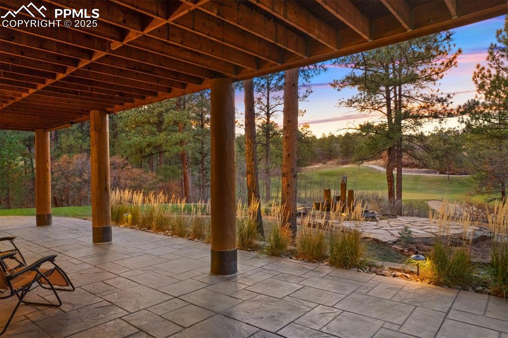 Image 30 of 41: The lower covered patio offers shaded seating and a hot tub