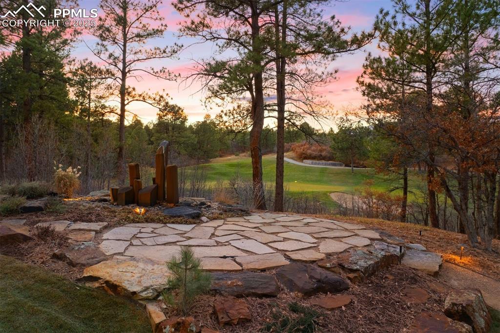 Image 32 of 41: A flagstone walkway leads to an additional flagstone patio with a sculptura