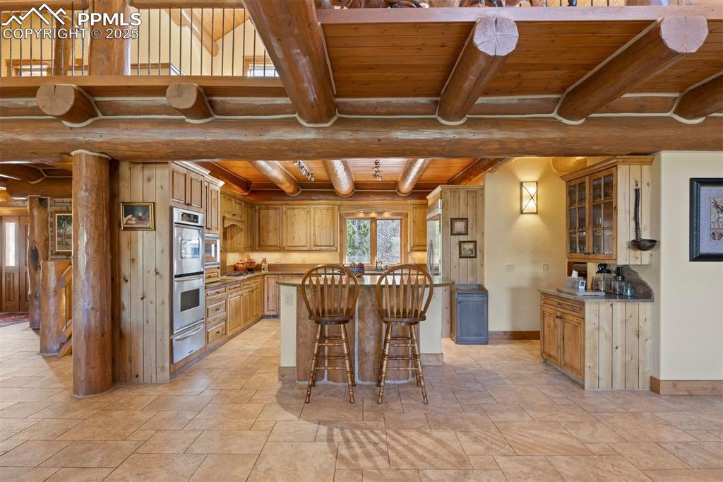 Image 7 of 41: The gourmet kitchen is appointed with quartzite countertops and knotty alde