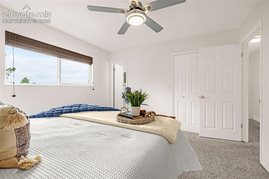 Image 10 of 44: Bedroom featuring light-colored walls and a window with a woven Roman shade