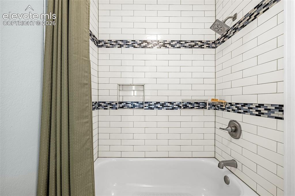 Image 12 of 44: Bathroom featuring a white vanity with integrated sink, white overhead cabi