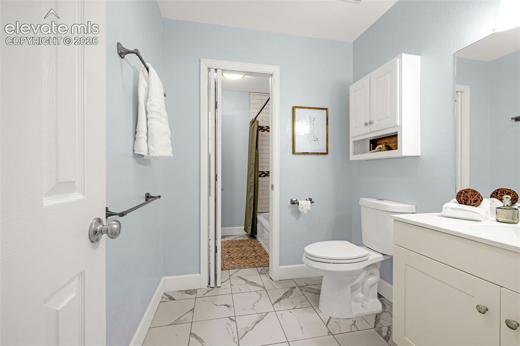 Image 13 of 44: Bathtub with white subway tile surround, accented by a decorative mosaic ti