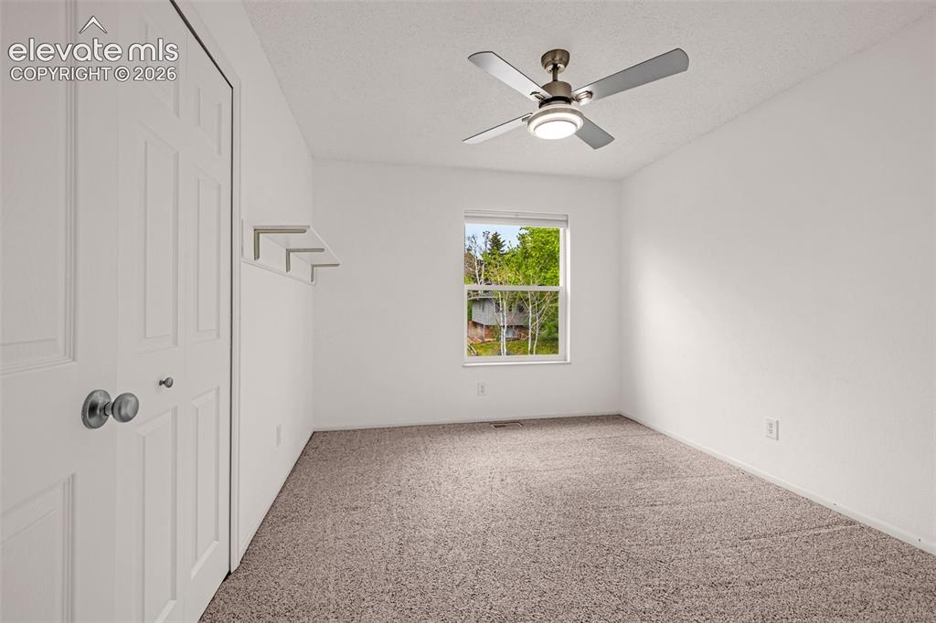 Image 15 of 44: Carpeted upper-level secondary bedroom space featuring a single window, a c