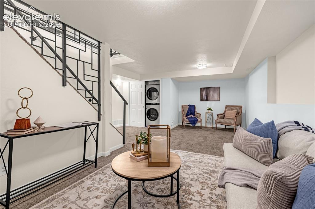 Image 17 of 44: Finished lower-level space featuring a brick-arch fireplace, plush carpet f