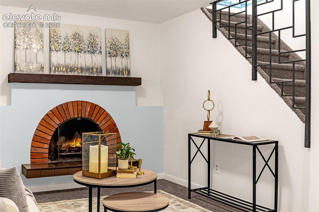 Image 18 of 44: Carpeted living area featuring a decorative metal staircase railing, recess