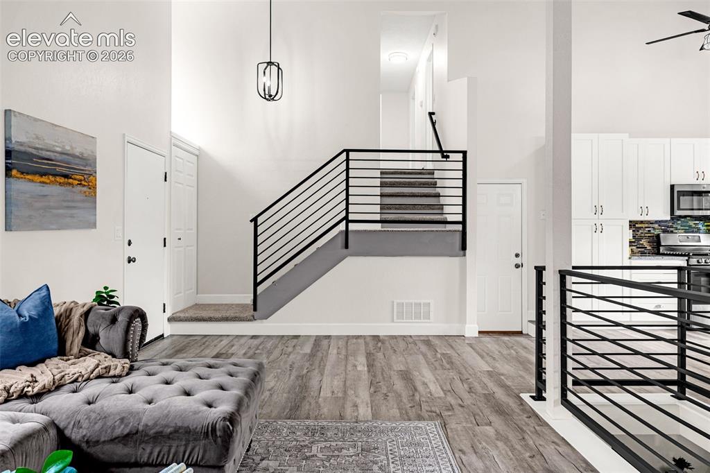 Image 24 of 44: Vaulted ceilings with exposed beam, wood-finish flooring, contemporary gray