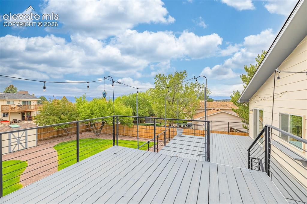 Image 26 of 44: Spacious outdoor deck with a gray finish, featuring custom gray metal raili