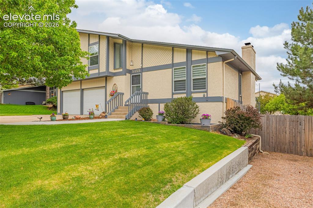 Image 30 of 44: Spacious backyard with manicured lawn, established trees, and a functional 