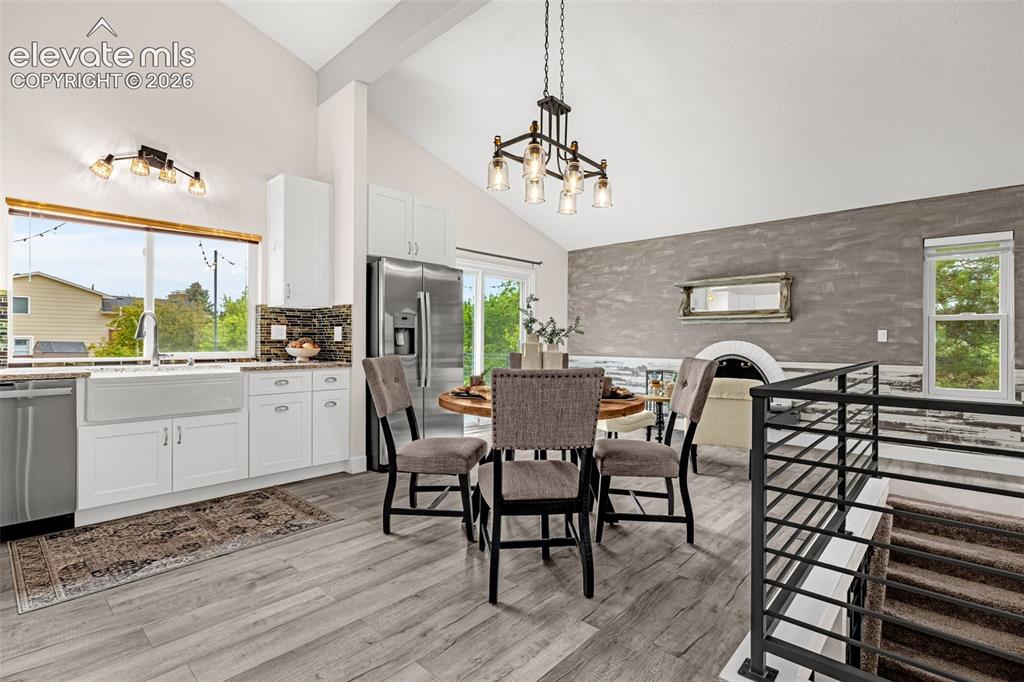 Image 4 of 44: Contemporary kitchen featuring white cabinetry, stainless steel appliances,