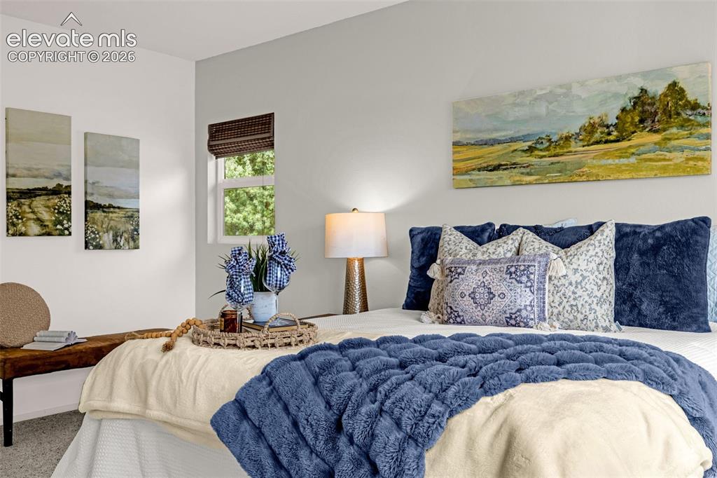 Image 9 of 44: Bright primary bedroom featuring a window with a woven shade, a ceiling fan