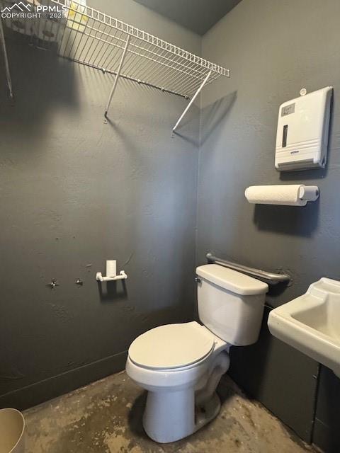 Image 9 of 9: Bathroom featuring toilet and a textured wall