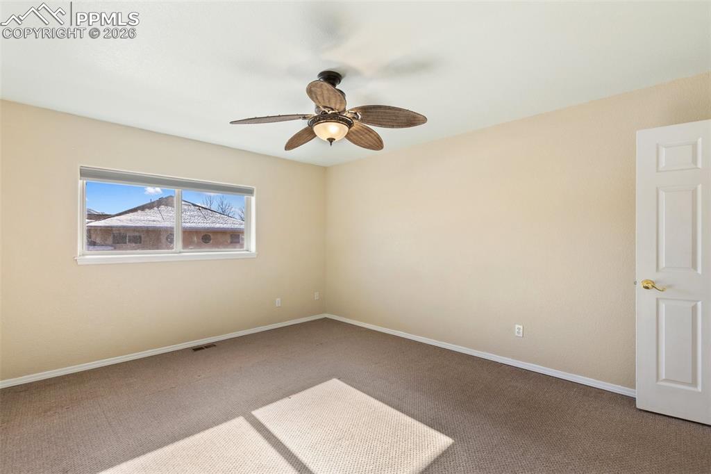 Image 16 of 36: Carpeted spare room with baseboards and a ceiling fan